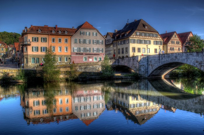 Buildings and bridge reflected in a river in Germany