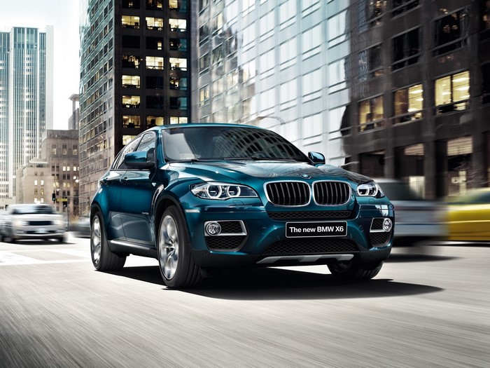 The new BMW X6 driving in a city