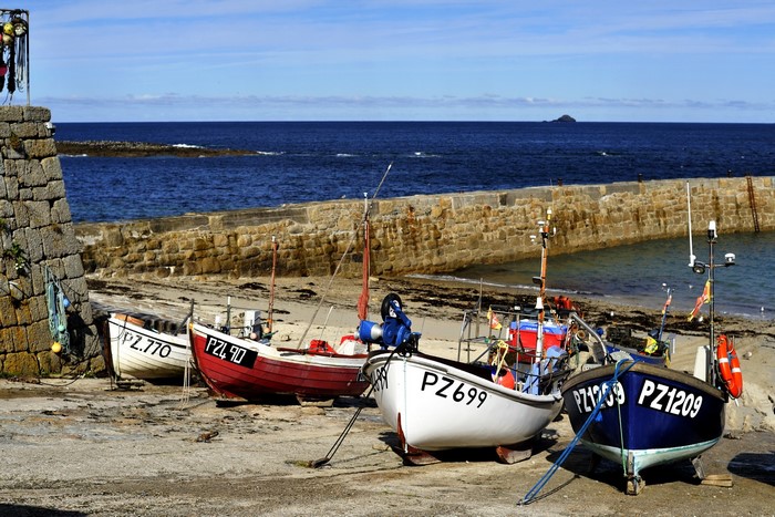 Fishing boats moored in a harbor with stone walls