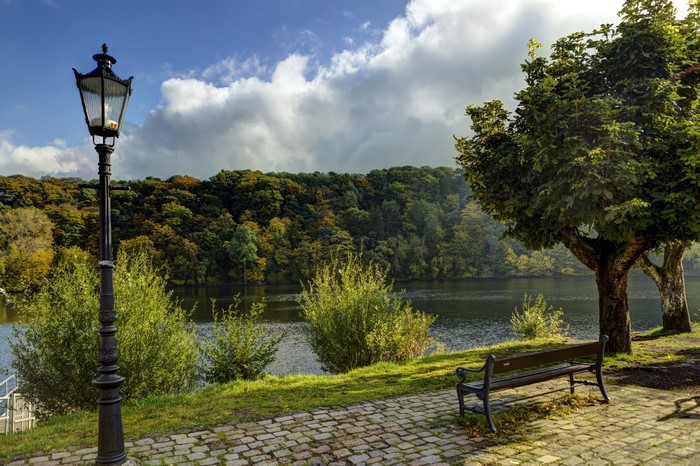 Park bench and lamppost by a lake in Germany