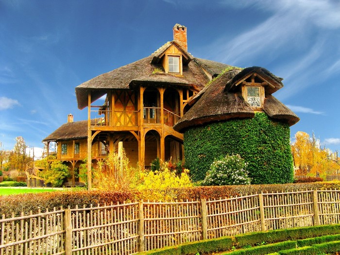 Thatched roof cottage with ivy-covered tower in France