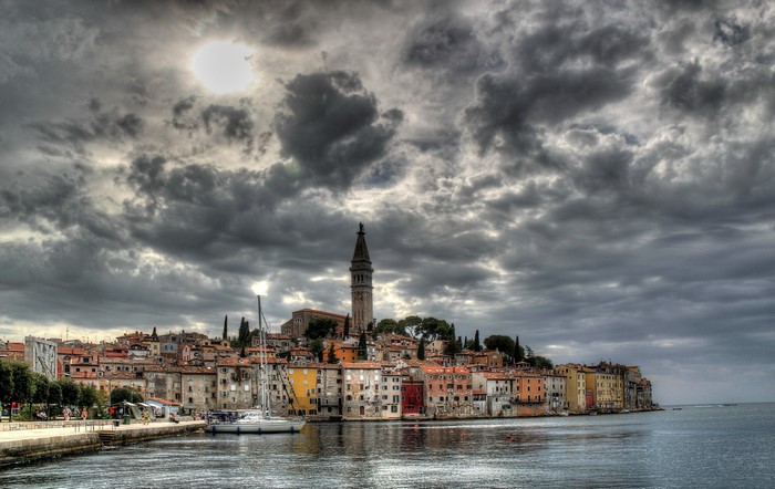 Coastal town with bell tower and sailboats in Croatia