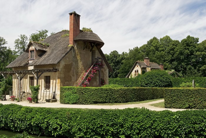 Thatched-roof cottages in a garden setting