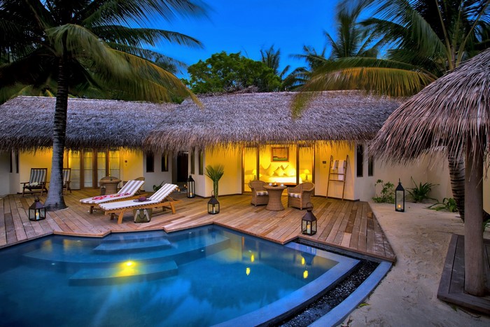 Maldives resort bungalow with private pool and lounge chairs
