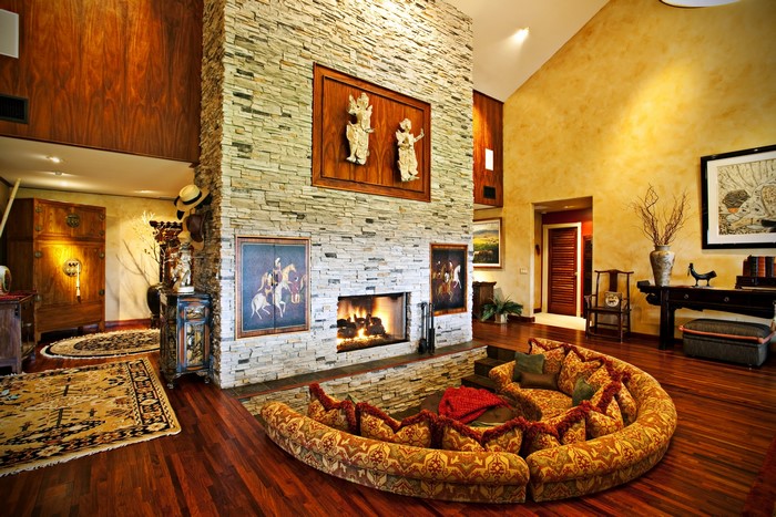 Living room with stone fireplace and circular sofa