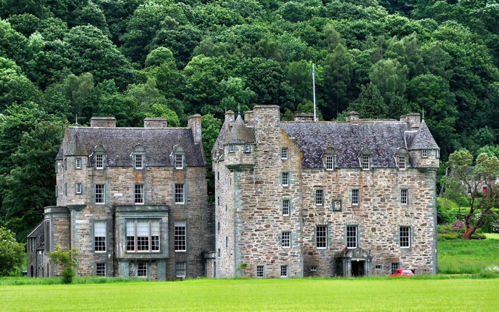 Menzies Castle in Scotland with a forest background