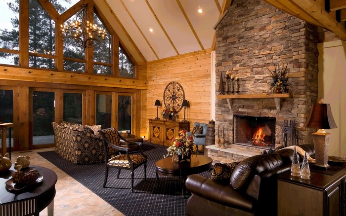 Rustic living room with stone fireplace and large windows