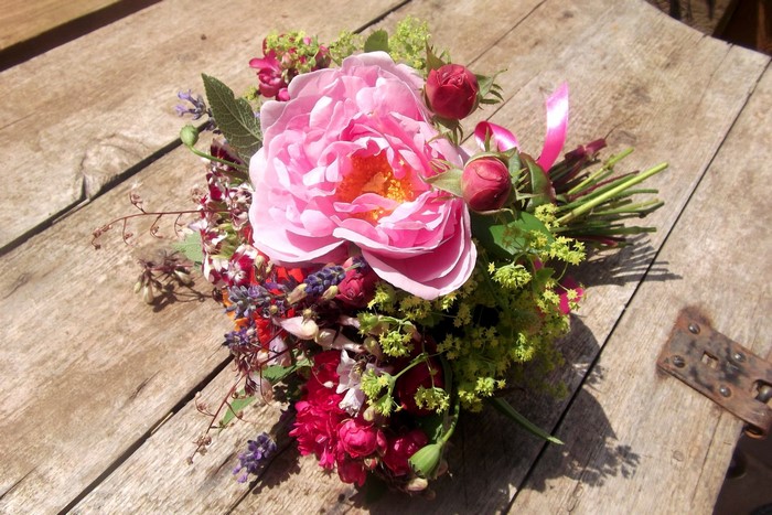 Bouquet of pink roses and lavender on a wooden table