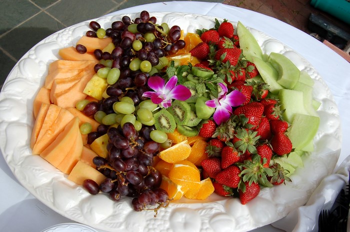Fruit platter with grapes, strawberries, melon, and oranges