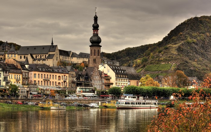 Town on a river with a church tower and a hill in Germany