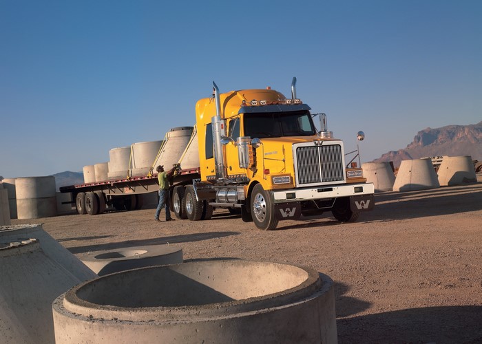 Yellow Western Star Truck hauling concrete pipes