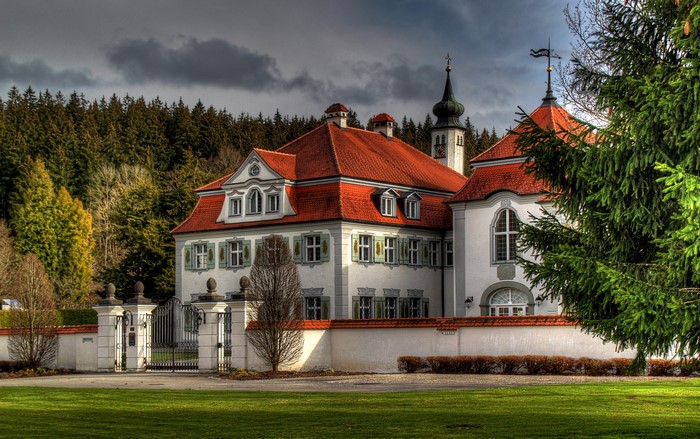 White mansion with red roof and forest in Germany