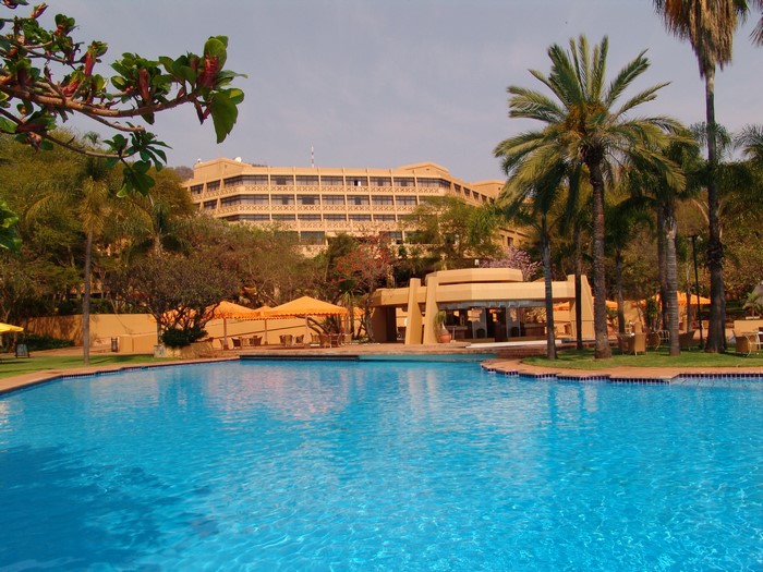 Resort pool with hotel and palm trees in Sun City, South Africa