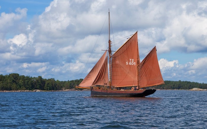 Sailing boat with red sails on the water