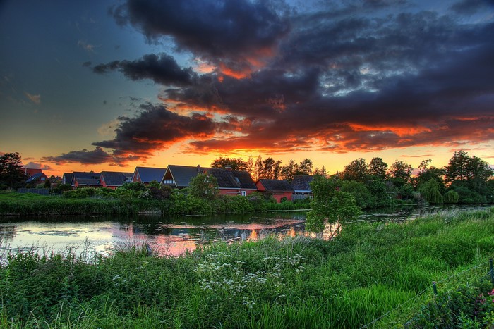 Houses by a river at sunset