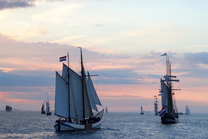 Sailing ships on the water at sunset