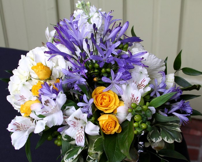 Bouquet of yellow roses, white hydrangeas, and purple agapanthus