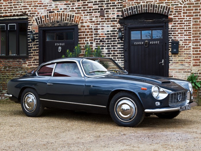 Dark blue Lancia Flavia Coupe parked in front of a brick building