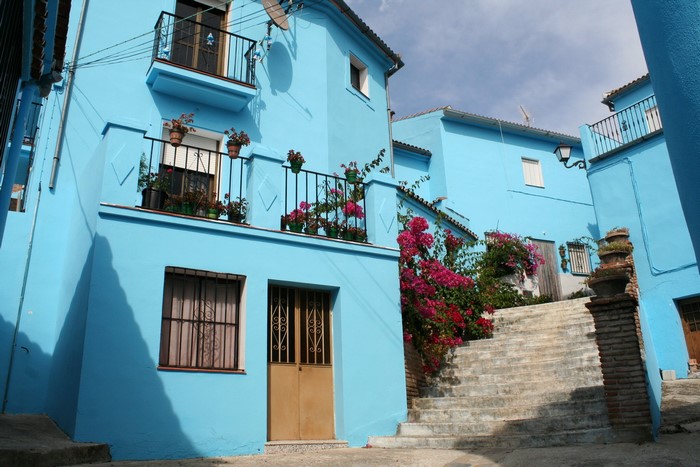 Blue houses with balconies and flowers in Spain