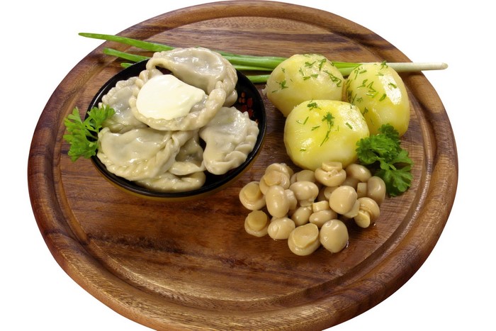 Dumplings with potatoes and mushrooms on a wooden board