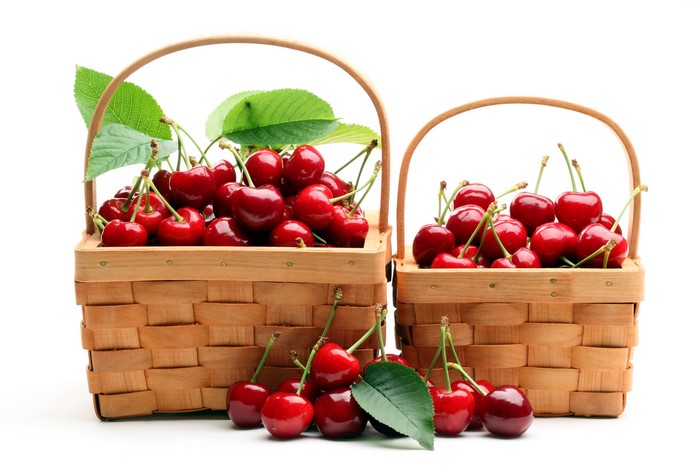 Two baskets of fresh cherries with leaves