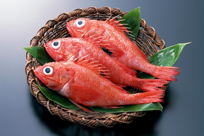 Three red rockfish in a basket with leaves