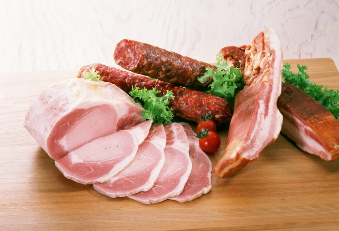 Assortment of cured meats and ham on a wooden board