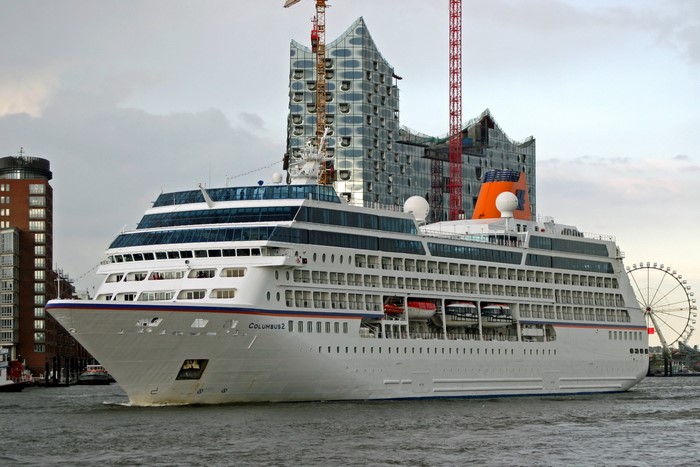 Cruise liner Columbus 2 in a harbor with modern buildings