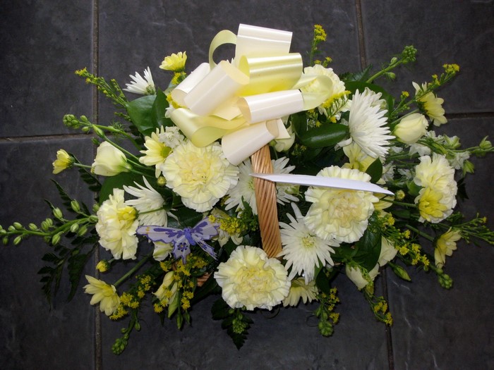 Yellow and white flower arrangement in a basket
