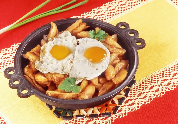 Fried eggs and potatoes in a pan
