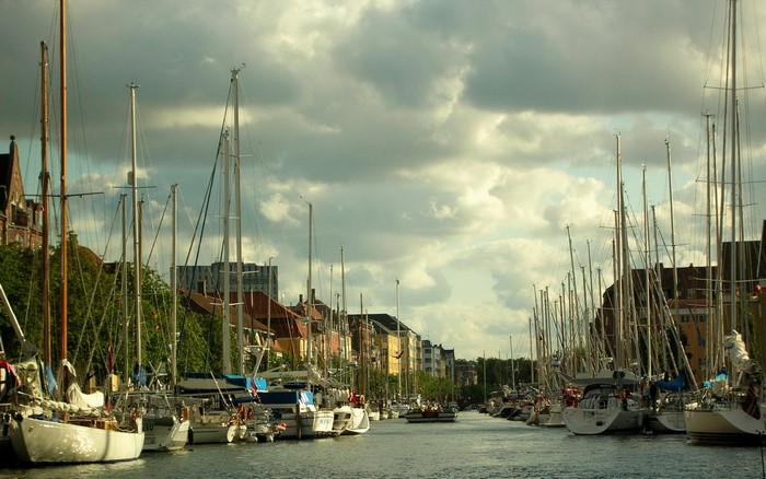 Sailboats docked in a canal with buildings in the background