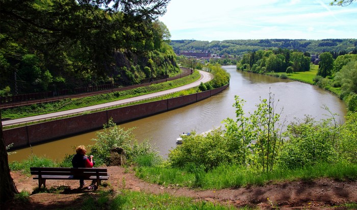 Woman on bench overlooking river and canal in Germany