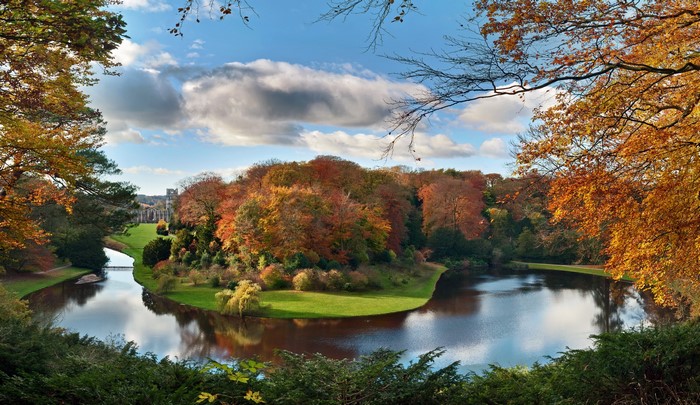 Autumn landscape with a river and a historic building in England