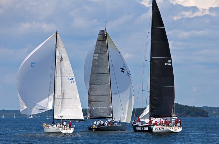 Three sailboats racing on a sunny day