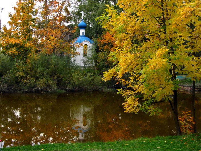 Chapel reflected in a lake during autumn in Russia