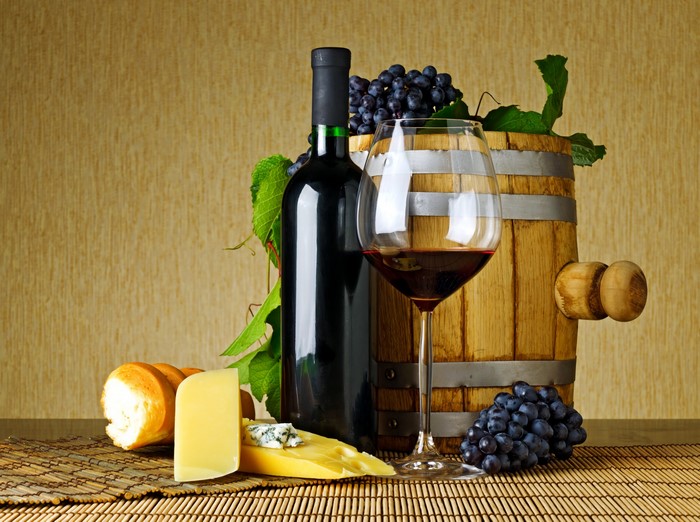 Wine bottle, glass, barrel, cheese, and bread
