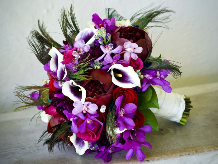 Purple and white calla lily and orchid bouquet with peacock feathers