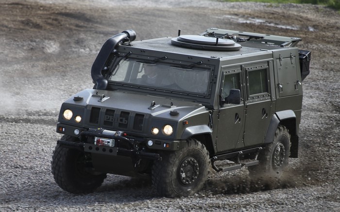 Military armored vehicle driving on gravel