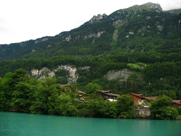 Iseltwald village by turquoise lake and mountains in Switzerland