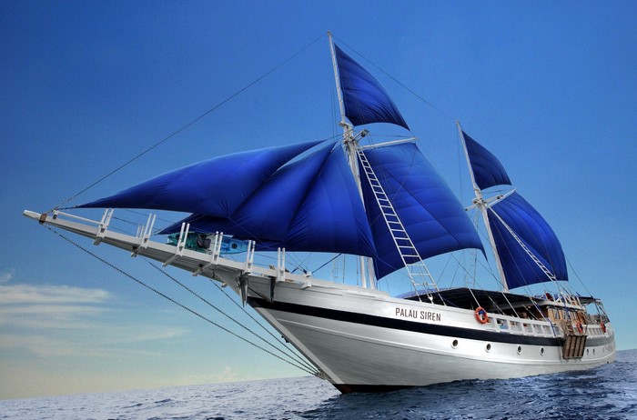 Palau Siren sailboat with blue sails on the ocean