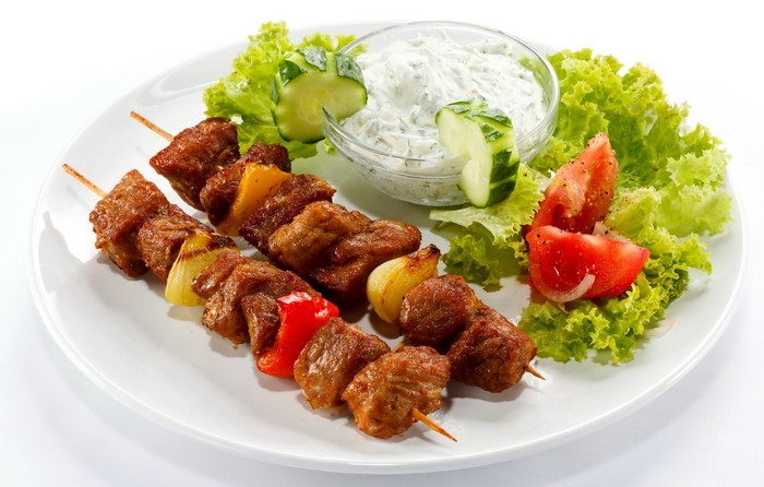 Meat skewers with tzatziki sauce and salad