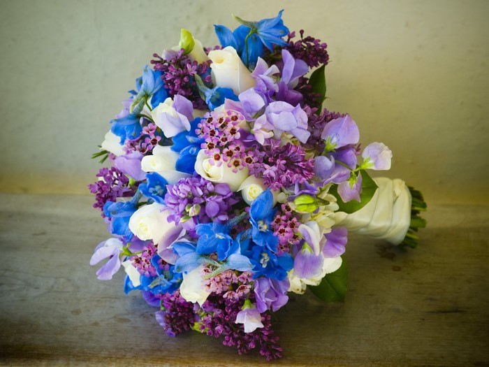 Wedding bouquet with white roses and blue and purple flowers