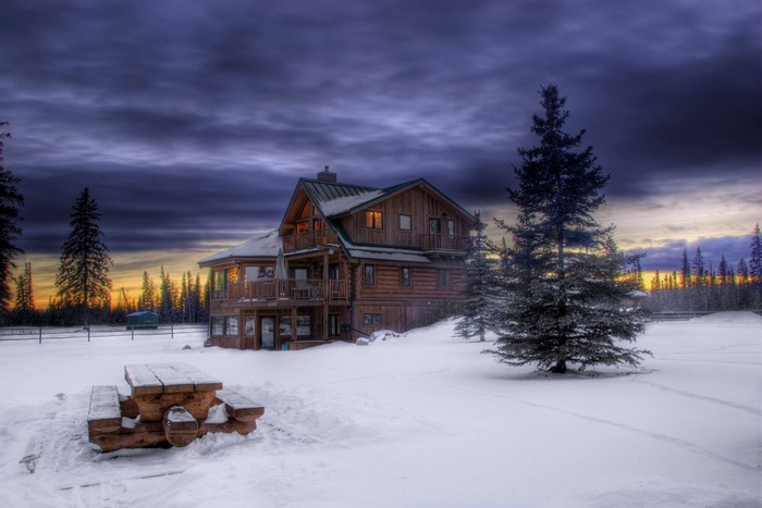Log cabin in the snow at sunset
