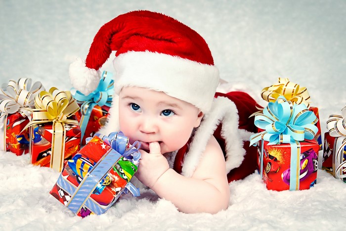 Baby in Santa hat with Christmas gifts