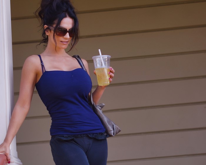 Denise Milani wearing sunglasses and a blue singlet