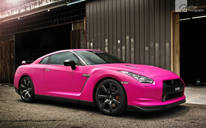 Pink Nissan GT-R parked outside a building