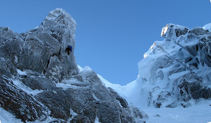 Climber on a snow-covered rocky mountain face