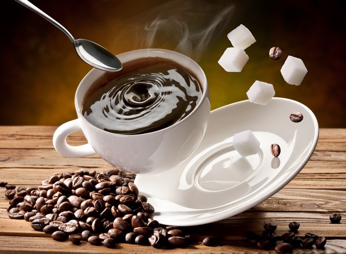 Coffee cup with sugar cubes and coffee beans