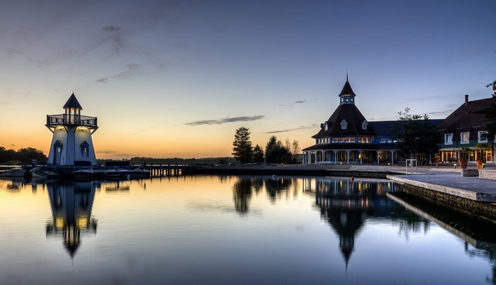 Lighthouse and building by the water at sunset