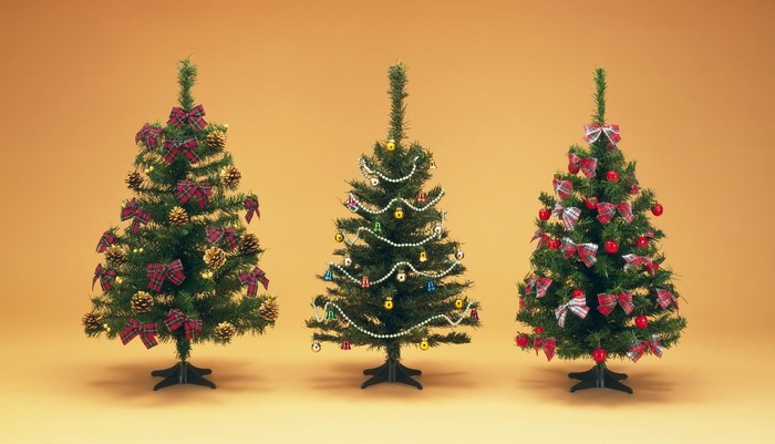Three decorated Christmas trees on an orange background